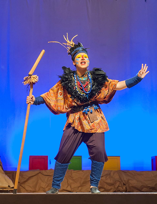 Child portraying Rafiki on stage in The Lion King Musical