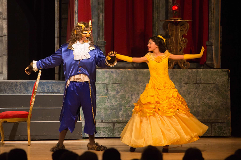 Kids playing The Beast and Belle on stage in Beauty and the Beast theater production